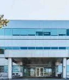 Exterior view of a modern multi-storey office building with glass windows and a covered front entrance in Dartmouth.