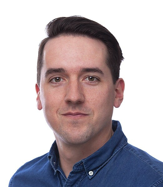 Man wearing a blue button-up shirt against a white background.