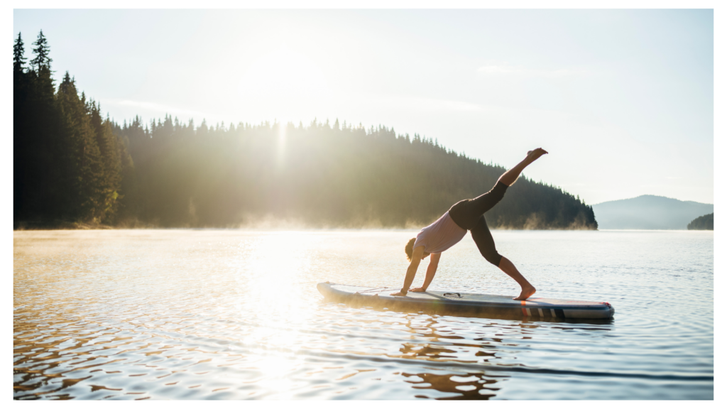 Young Man Doing Yoga Pose On Paddle Board